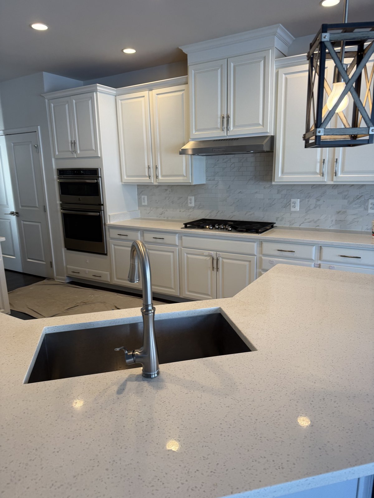 White kitchen with quartz island and marble backsplash