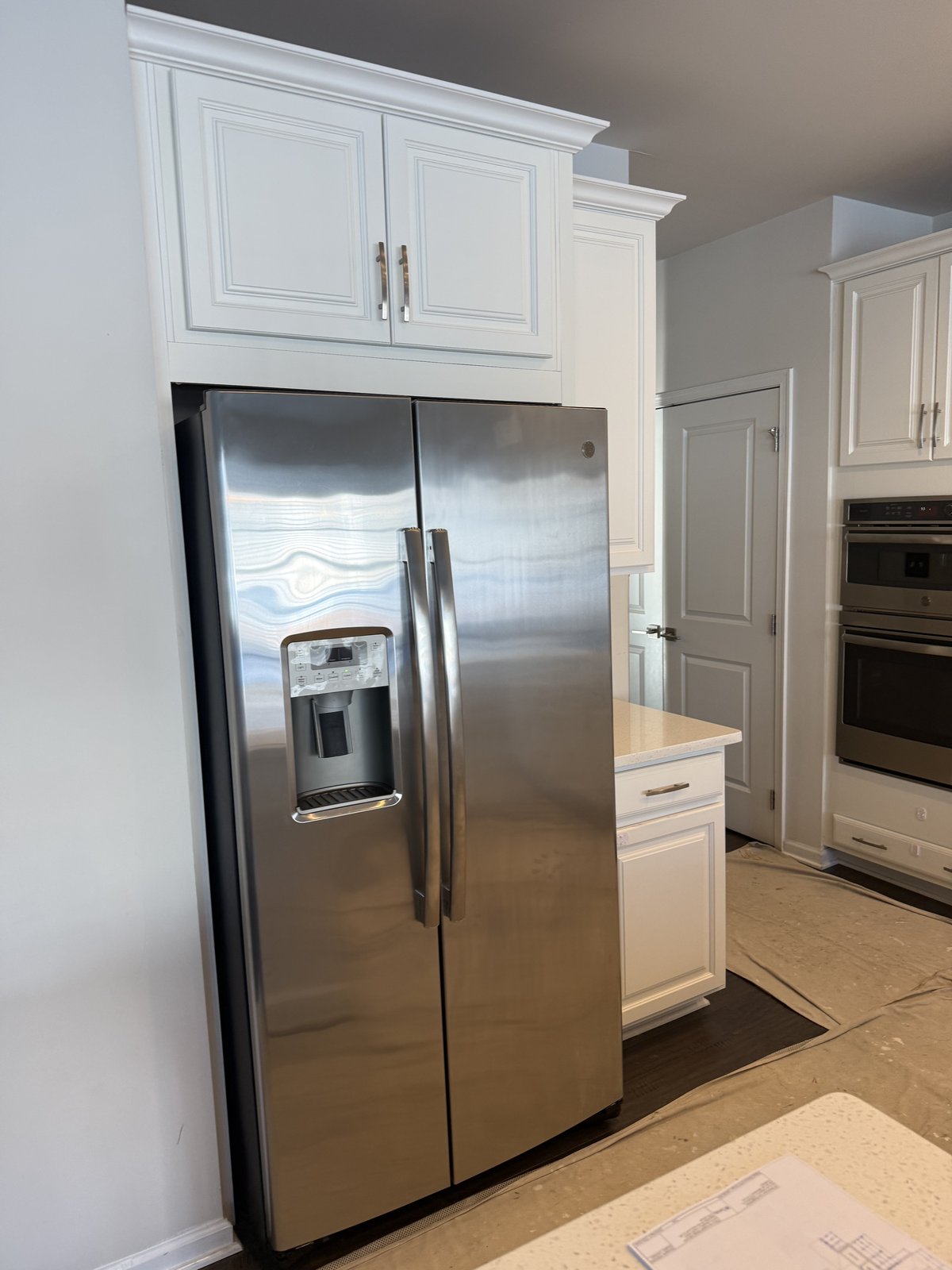 Stainless fridge with custom cabinet surround