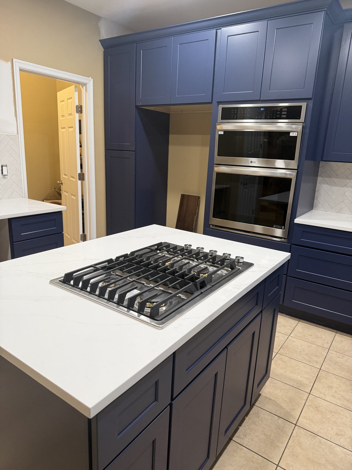 Navy blue kitchen island detail with double wall oven